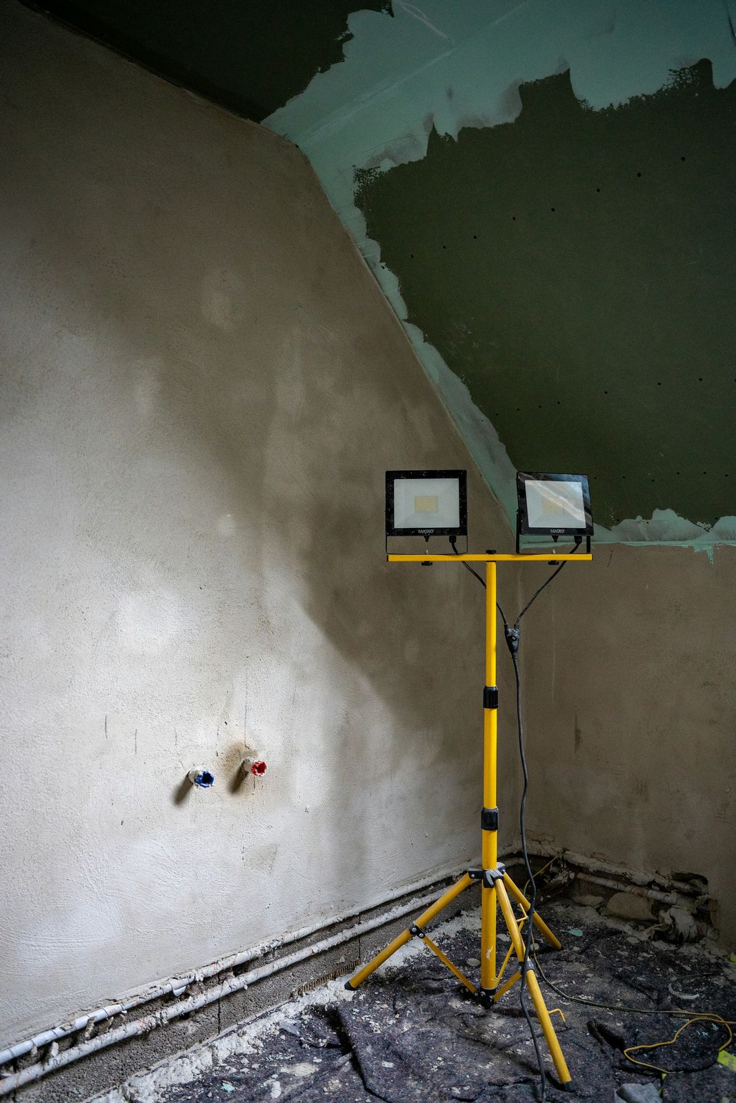 House renovation in progress with exposed pipework and plaster